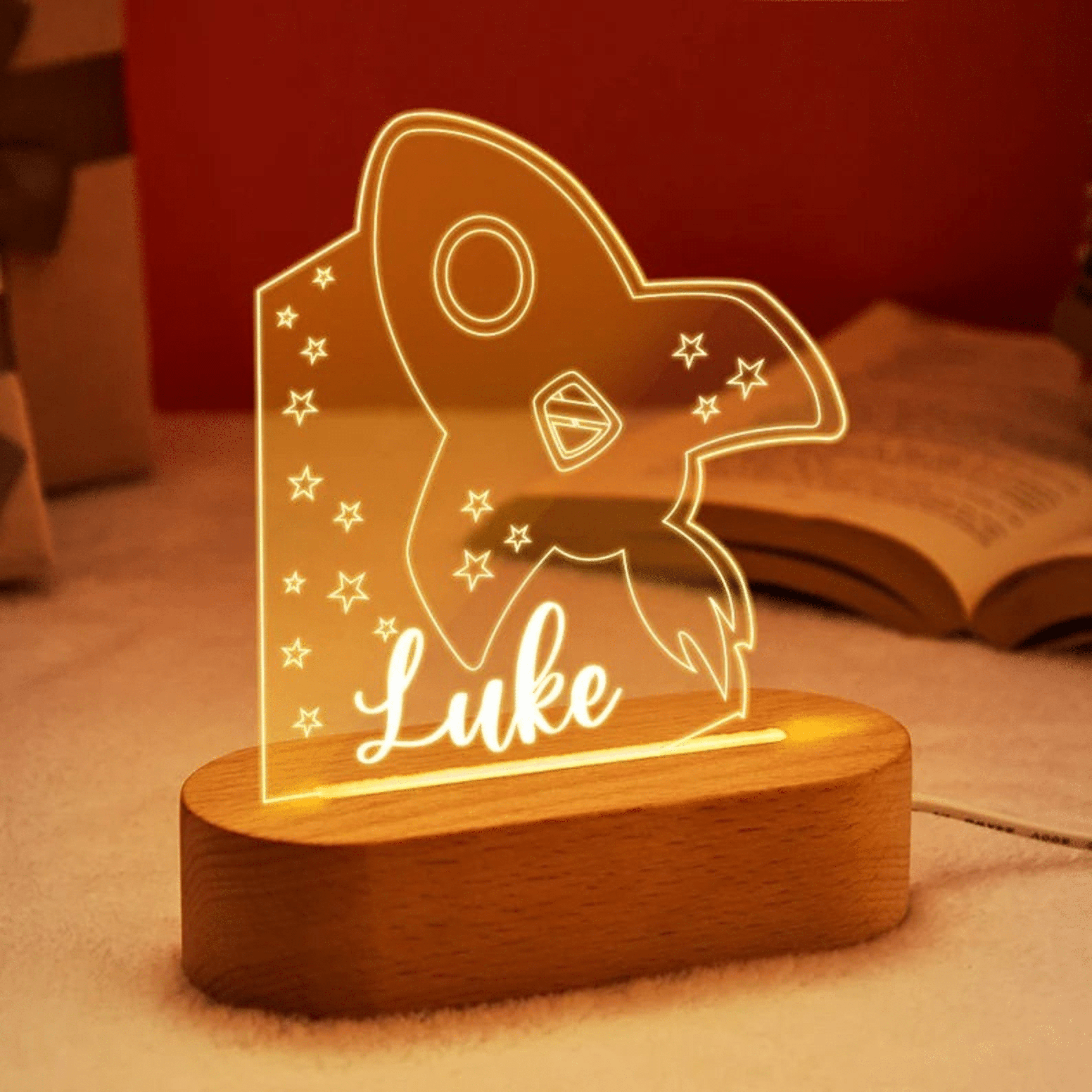 Veilleuse personnalisée fusée en acrylique avec étoiles, prénom gravé, base en bois avec éclairage LED doux, idéale pour une chambre d’enfant sur le thème de l’espace.