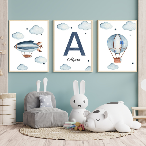Lot de trois affiches personnalisées avec un ballon dirigeable, une initiale et une montgolfière, dans une chambre d'enfant.