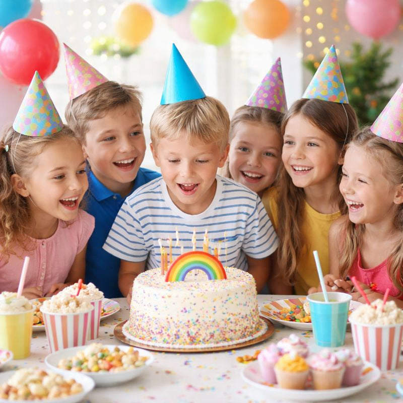 Enfants réunis pour un anniversaire découvrant une veilleuse à offrir comme cadeau, idéale pour créer une ambiance douce et magique dans la chambre.