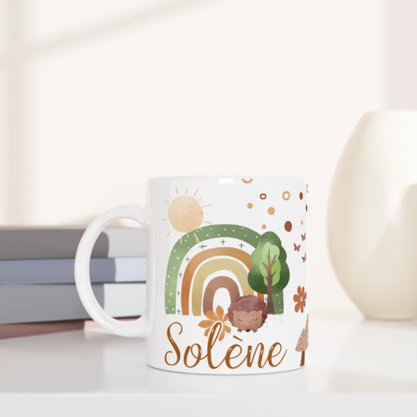 Mug personnalisé tout blanc avec arc-en-ciel bohème et petit hérisson, idéal pour un cadeau nature et chaleureux.