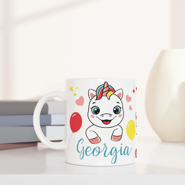 Mug personnalisé tout blanc avec licorne joyeuse et ballons colorés, idéal pour un cadeau enfant féerique et original.