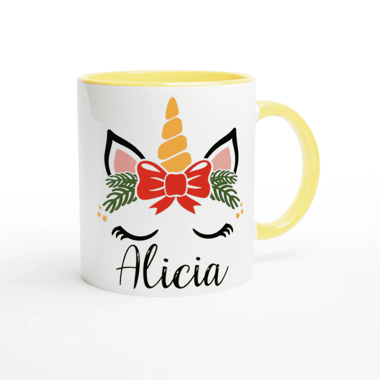 Mug blanc motif licorne de Noël avec feuillage vert et nœud rouge, anse jaune et intérieur jaune.