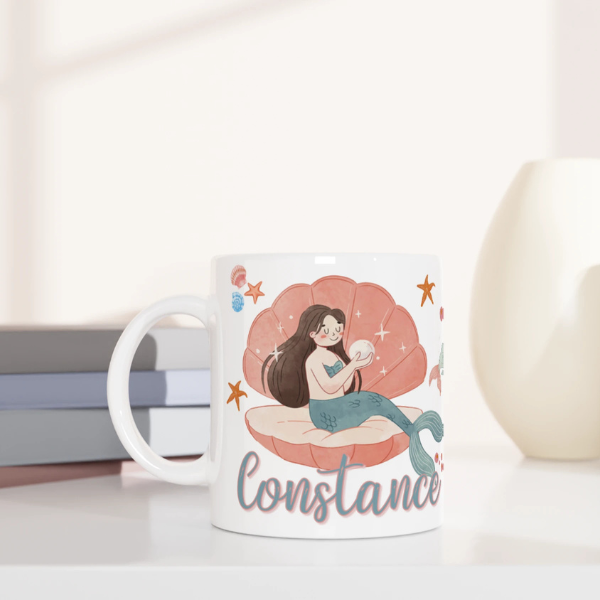 Mug personnalisé tout blanc avec illustration de sirènes aquarelle, décor marin et coquillages, idéal pour un cadeau enfant.