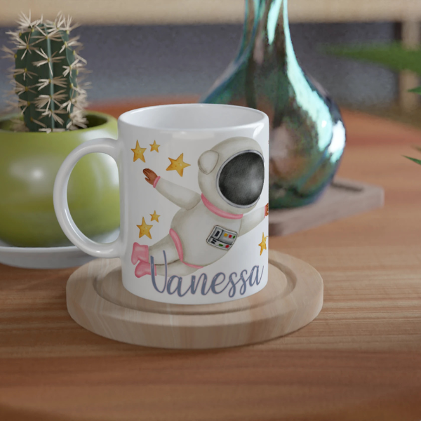 Mug personnalisé tout blanc avec astronaute en combinaison rose et fusée, idéal pour un cadeau enfant original et ludique.