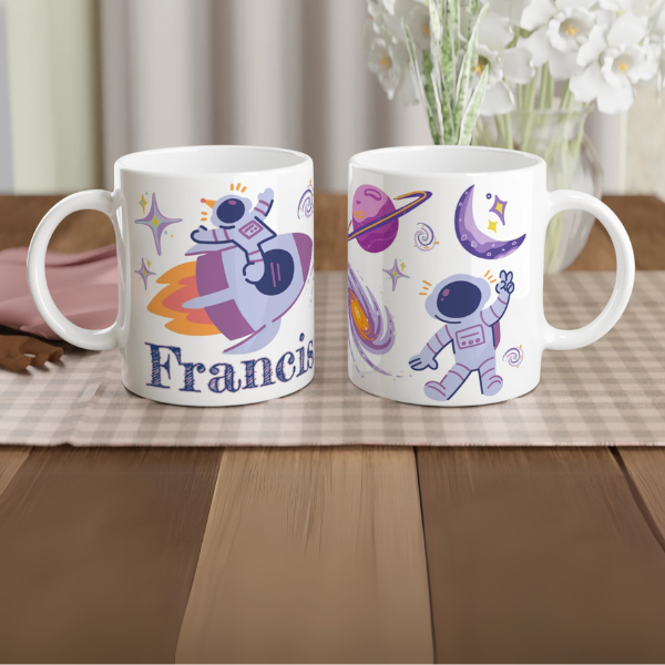 Mug personnalisé tout blanc avec illustration d’un astronaute sur une fusée dans l’espace, parfait pour un cadeau enfant original.