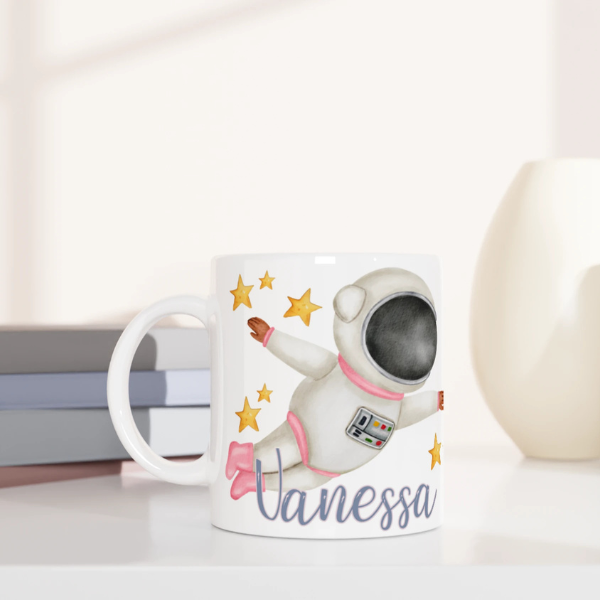 Mug personnalisé tout blanc avec astronaute en combinaison rose et fusée, idéal pour un cadeau enfant original et ludique.