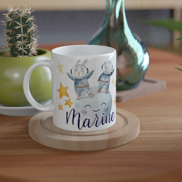Mug personnalisé tout blanc avec illustration de lapins astronautes flottant dans l’espace, parfait pour un cadeau enfant original.