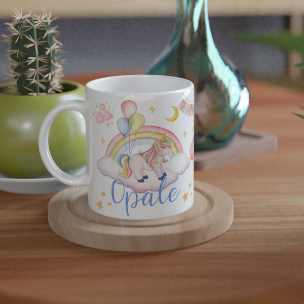 Mug personnalisé tout blanc avec licorne sur un nuage et montgolfière féerique, idéal pour un cadeau magique et enchanteur.
