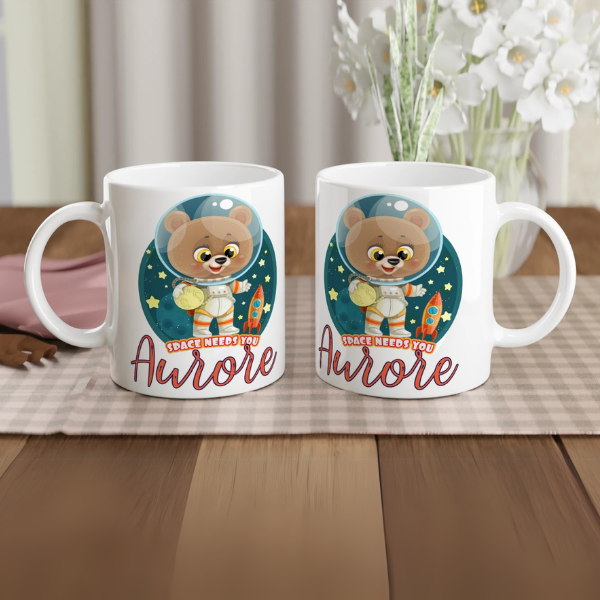 Mug personnalisé tout blanc avec ourson astronaute tenant une planète, parfait pour un cadeau enfant original et ludique.