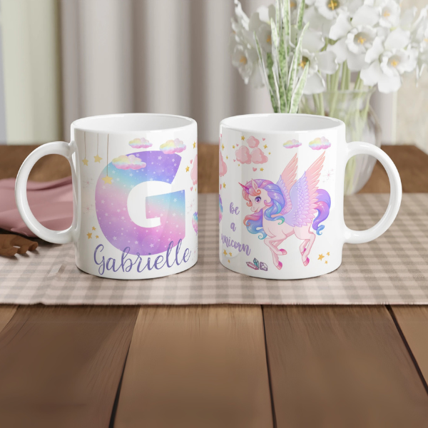 Mug personnalisé tout blanc avec licorne ailée et lettre initiale étoilée, idéal pour un cadeau magique et féerique.