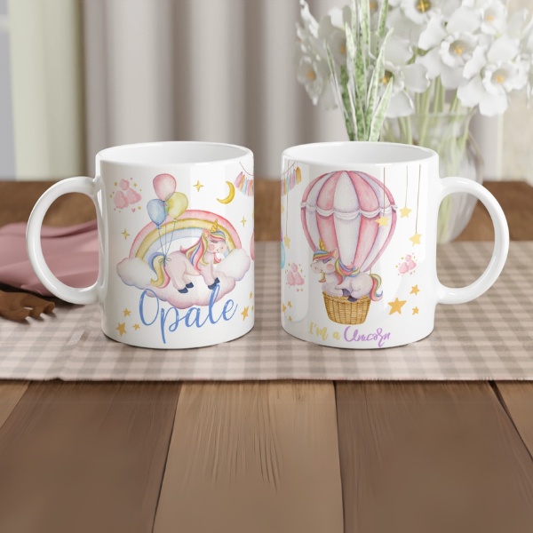 Mug personnalisé tout blanc avec licorne sur un nuage et montgolfière féerique, idéal pour un cadeau magique et enchanteur.