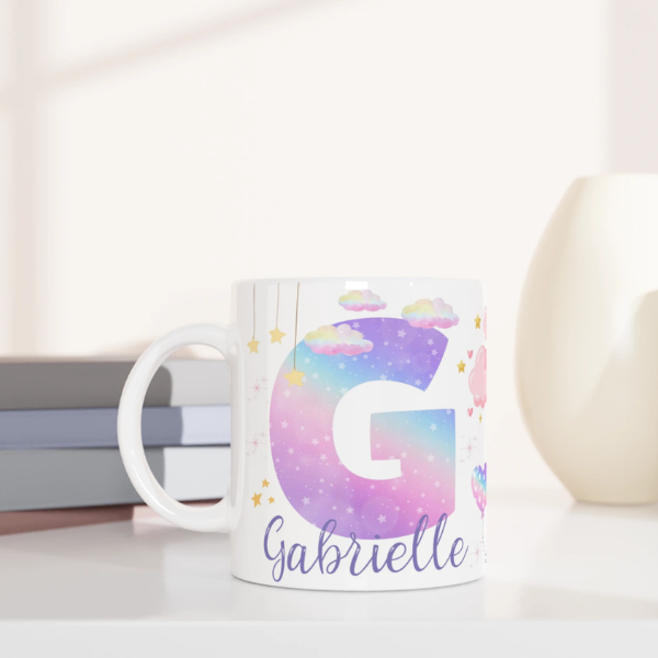 Mug personnalisé tout blanc avec licorne ailée et lettre initiale étoilée, idéal pour un cadeau magique et féerique.