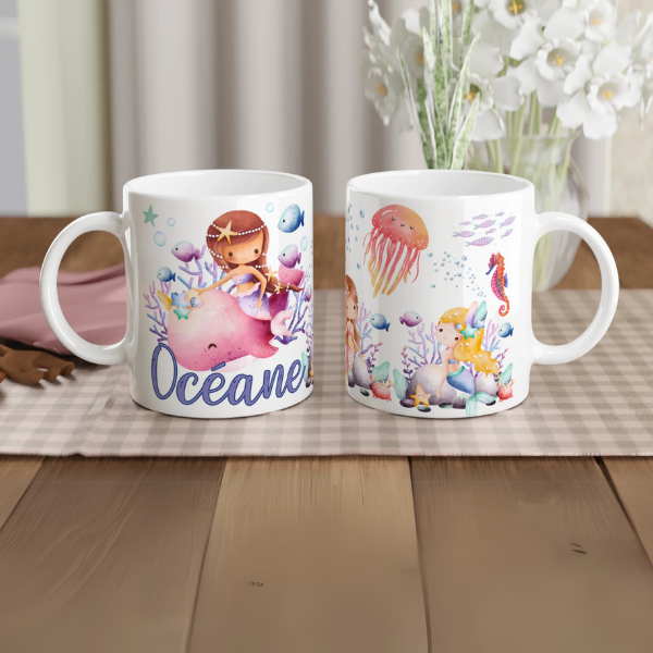 Mug personnalisé tout blanc avec illustration de sirènes et animaux marins, comme des méduses et hippocampes, idéal pour un cadeau enfant.