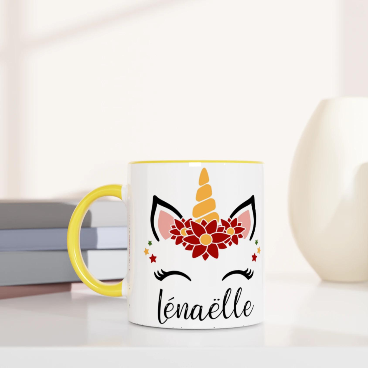 Mug blanc décor licorne de Noël avec couronne de fleurs rouges, étoiles festives et corne dorée, anse jaune et intérieur jaune.