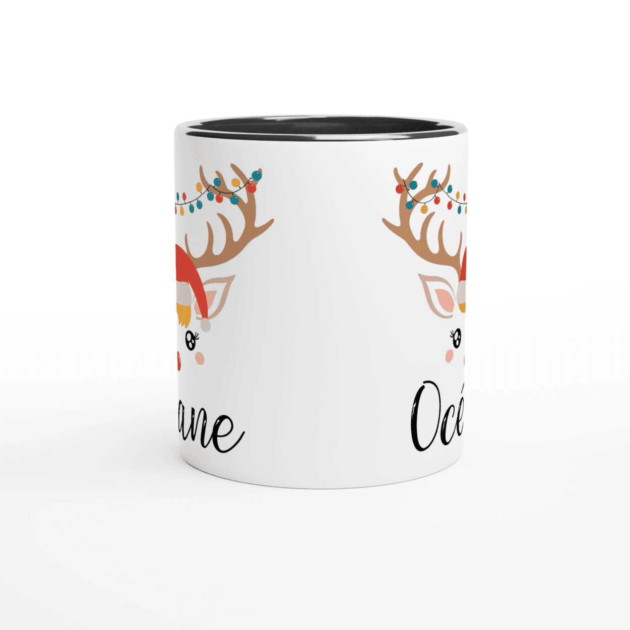 Mug de Noël avec visage de renne, bonnet rouge et guirlande lumineuse sur les bois, anse noire et intérieur noir.