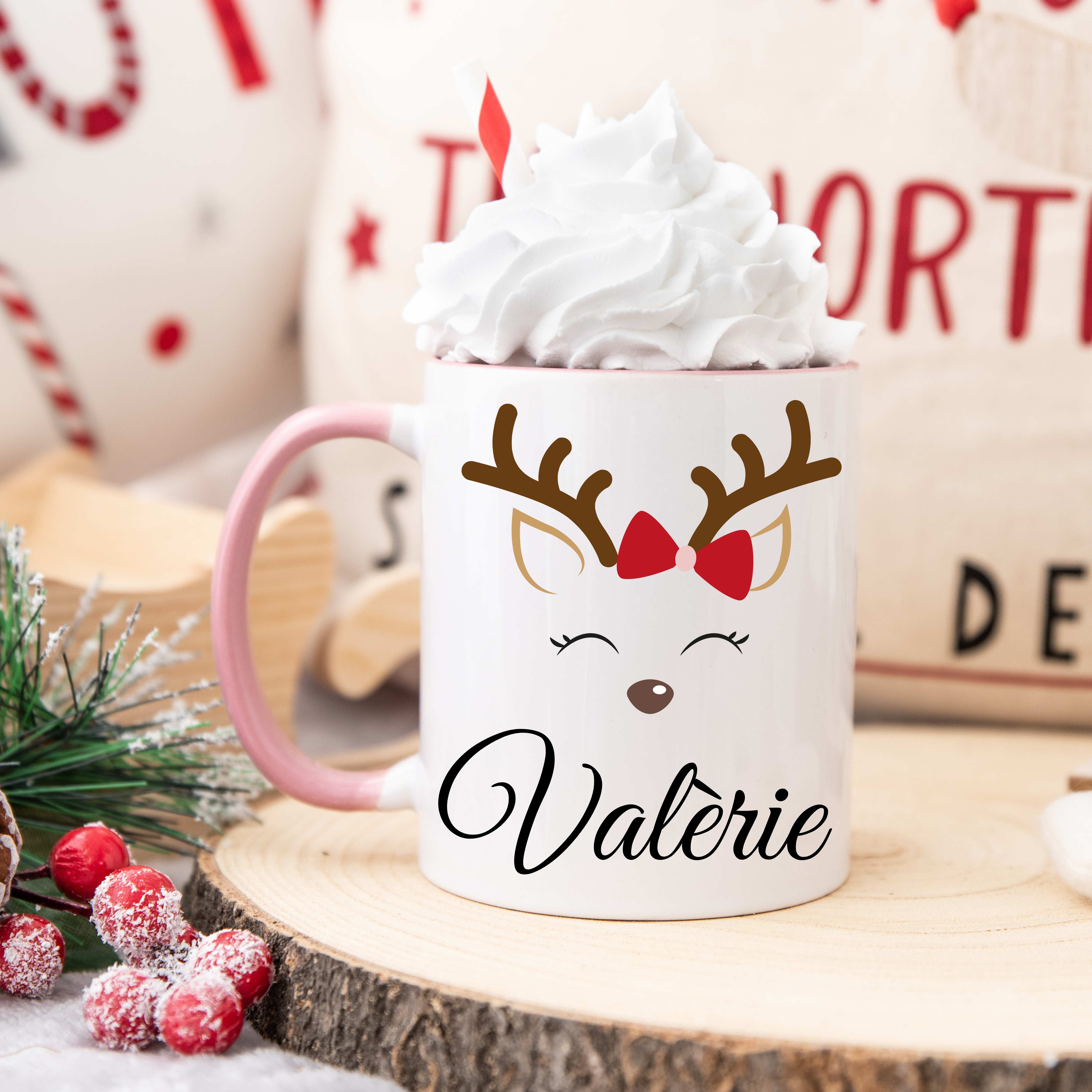 Mug de Noël blanc illustré d’un renne mignon aux yeux fermés avec nœud rouge, anse rose et intérieur rose.