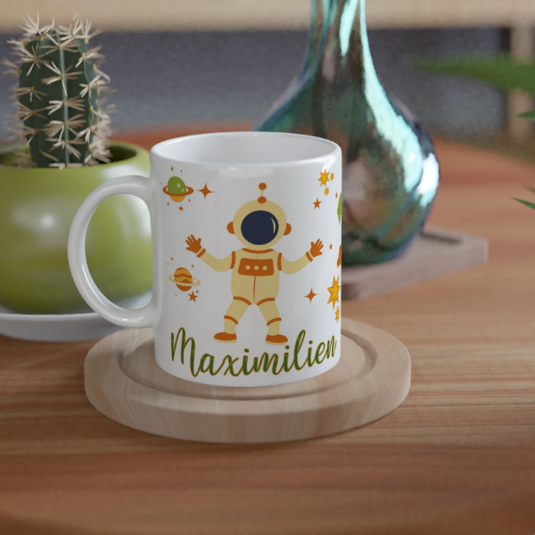 Mug personnalisé tout blanc avec astronaute et fusée entourés de planètes et étoiles, idéal pour un cadeau enfant original.