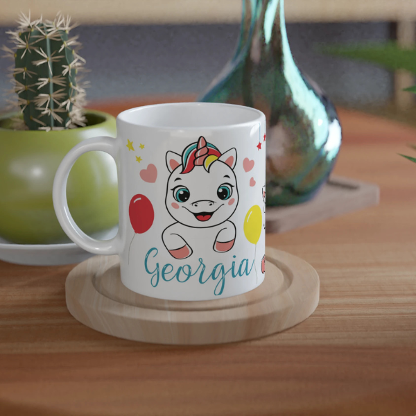 Mug personnalisé tout blanc avec licorne joyeuse et ballons colorés, idéal pour un cadeau enfant féerique et original.