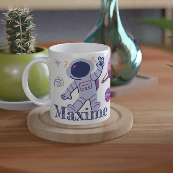 Mug personnalisé tout blanc avec illustration d’astronaute et soucoupe volante, un cadeau parfait pour les petits explorateurs de l’espace.