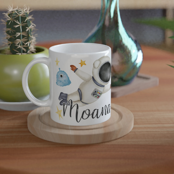 Mug personnalisé tout blanc avec astronaute flottant dans l’espace et extraterrestres, parfait pour un cadeau enfant original.