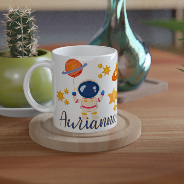 Mug personnalisé tout blanc avec astronaute flottant sur une planète, idéal pour un cadeau enfant original et ludique.