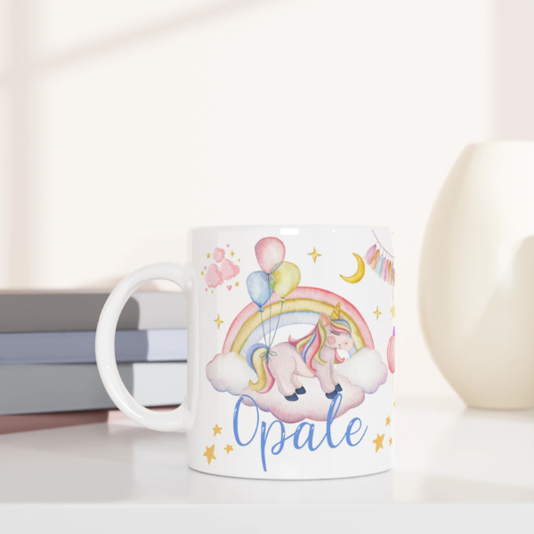 Mug personnalisé tout blanc avec licorne sur un nuage et montgolfière féerique, idéal pour un cadeau magique et enchanteur.