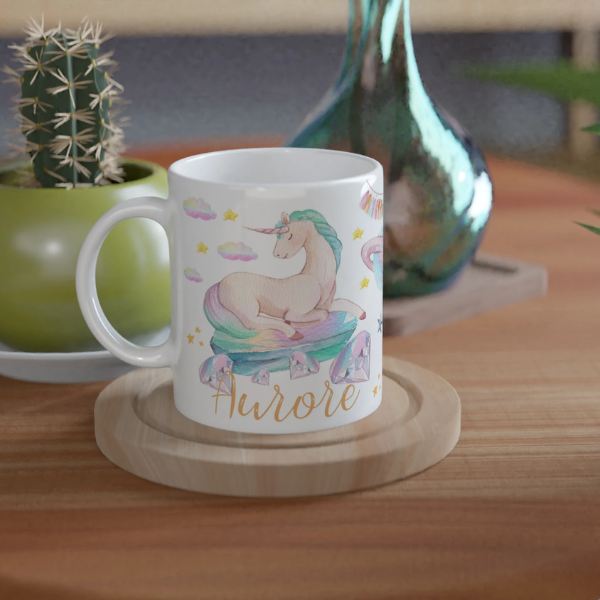 Mug personnalisé tout blanc avec licorne couchée sur un nuage pastel, idéal pour un cadeau féerique et enchanteur.