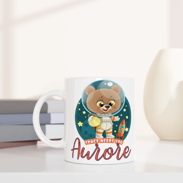 Mug personnalisé tout blanc avec ourson astronaute tenant une planète, parfait pour un cadeau enfant original et ludique.