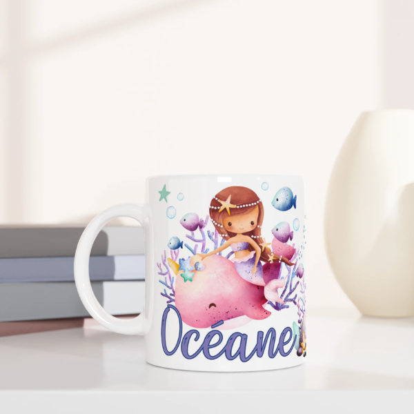 Mug personnalisé tout blanc avec illustration de sirènes et animaux marins, comme des méduses et hippocampes, idéal pour un cadeau enfant.