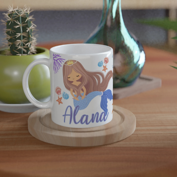 Mug personnalisé tout blanc avec illustration de sirène princesse, décor marin avec étoiles de mer et coraux, idéal pour un cadeau enfant.