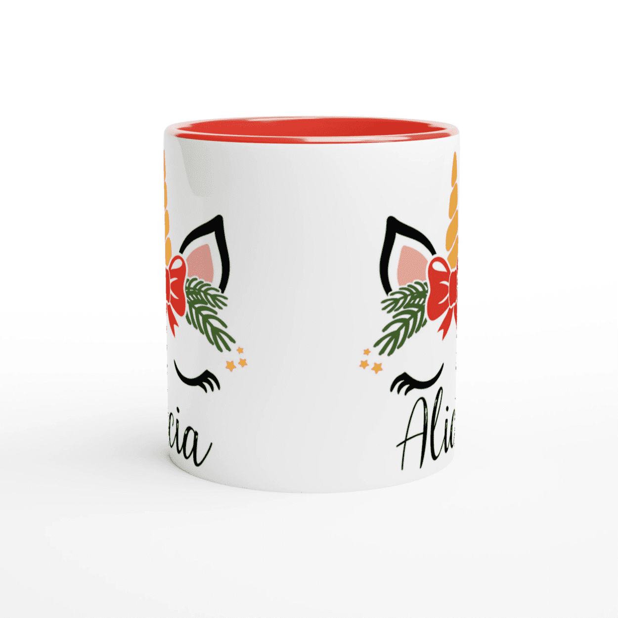 Tasse blanche décorée d’une licorne festive avec feuillage et nœud rouge, anse rouge et intérieur rouge.