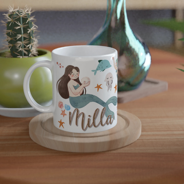 Mug personnalisé tout blanc avec illustration de sirènes aquarelle, décor marin et coquillages, idéal pour un cadeau enfant.