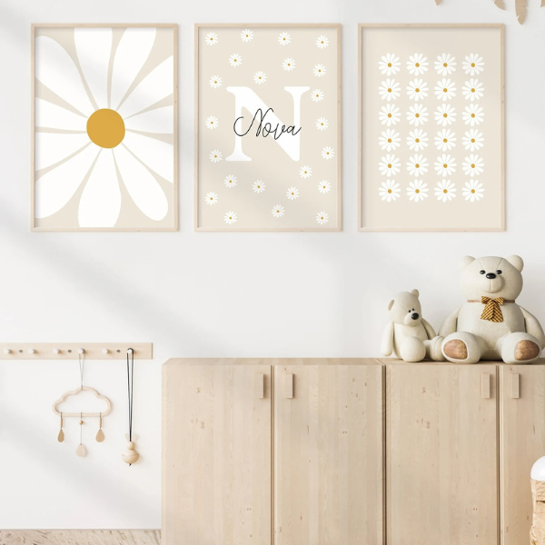 Triptyque d’affiches murales décoratives pour chambre d’enfant avec marguerites stylisées, tons beige et blanc, cadres en bois clair, ambiance douce et naturelle.