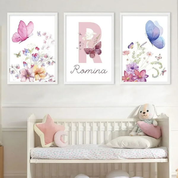 Triptyque d’affiches murales florales avec papillons pastel, installé dans une chambre bébé aux murs roses, avec jouets en bois, tapis graphique et décoration douce et poétique.