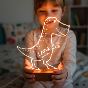 Enfant tenant une lampe veilleuse dinosaure en forme de stégosaure illuminée.