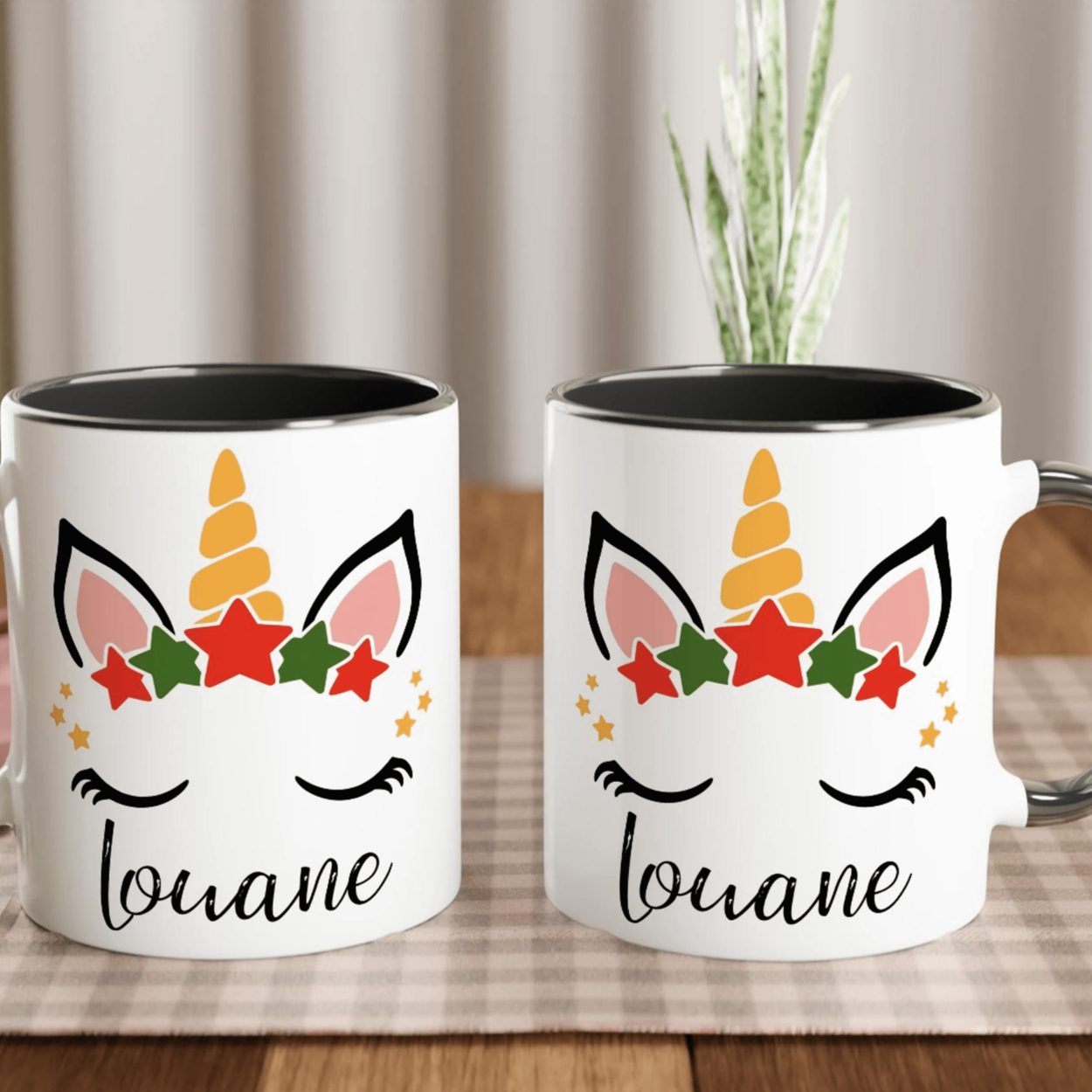 Mug licorne de Noël avec corne dorée et couronne d’étoiles rouges et vertes, anse noire et intérieur noir.
