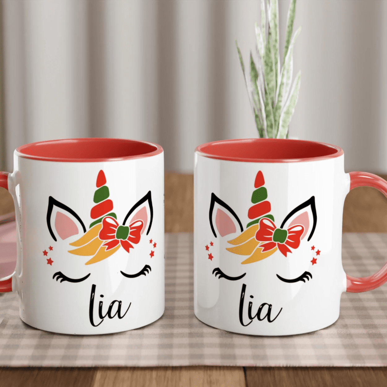 Mug licorne de Noël décoré d’un noeud rouge, anse rouge et intérieur rouge, design festif avec étoiles.