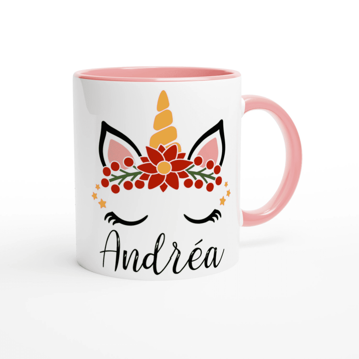 Mug licorne blanc intérieur rose et anse rose posé sur une table avec boisson chaude et décoration hivernale