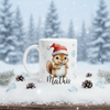 Mug de Noël personnalisé avec illustration d’écureuil portant un bonnet de Noël, posé dans un décor hivernal enneigé