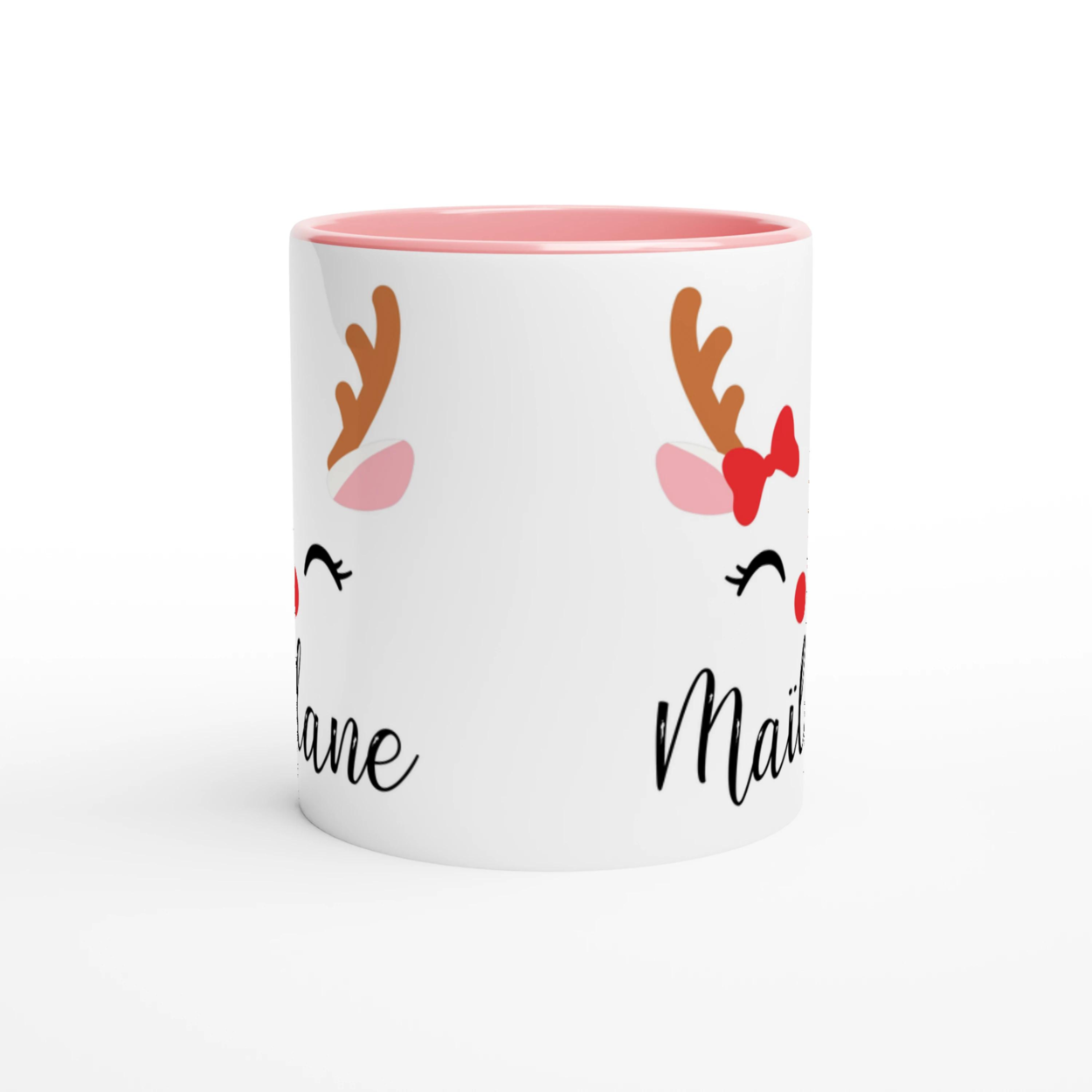 Mug de Noël décoré d’un renne festif avec nœud rouge et bois stylisés, anse rose et intérieur rose.