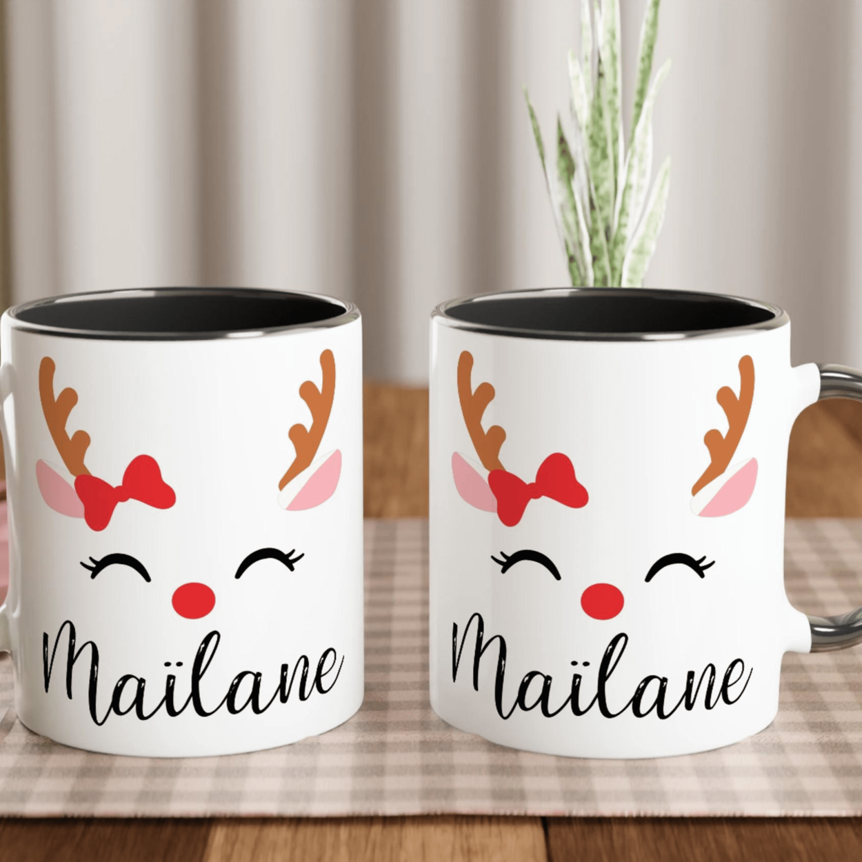 Mug de Noël avec visage de renne souriant, bois marron et nœud rouge, anse noire et intérieur noir.