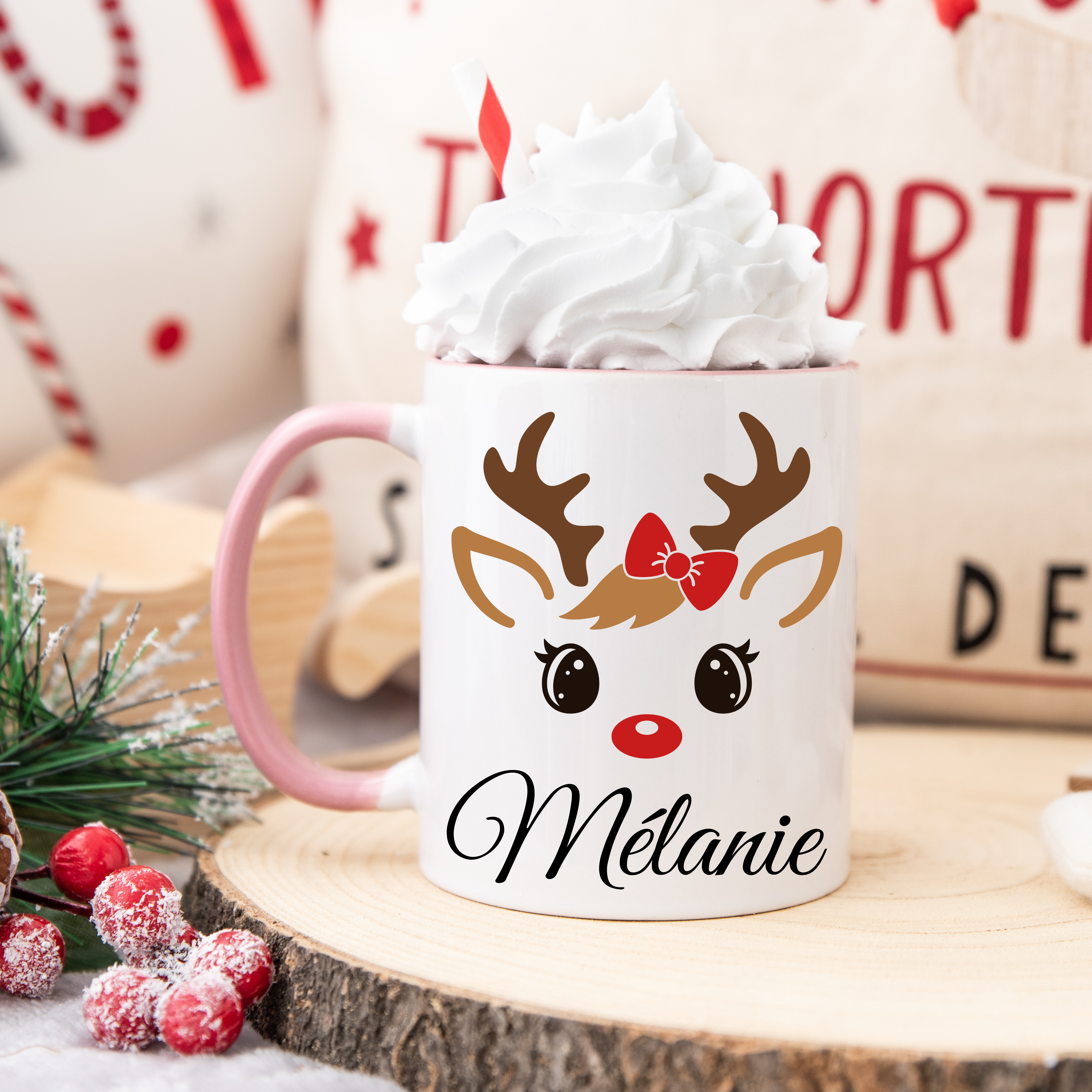 Mug de Noël illustré d’un renne mignon aux yeux ouverts et nœud rouge, anse rose et intérieur rose.