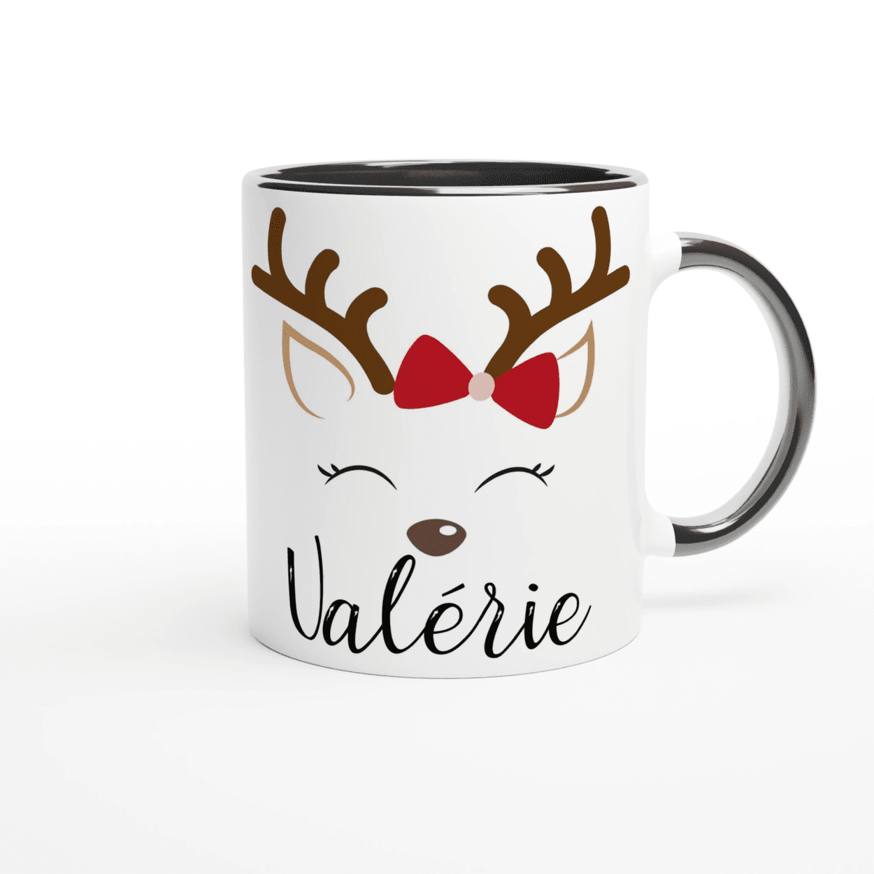 Mug de Noël blanc avec illustration de renne aux yeux fermés et nœud rouge, anse noire et intérieur noir.