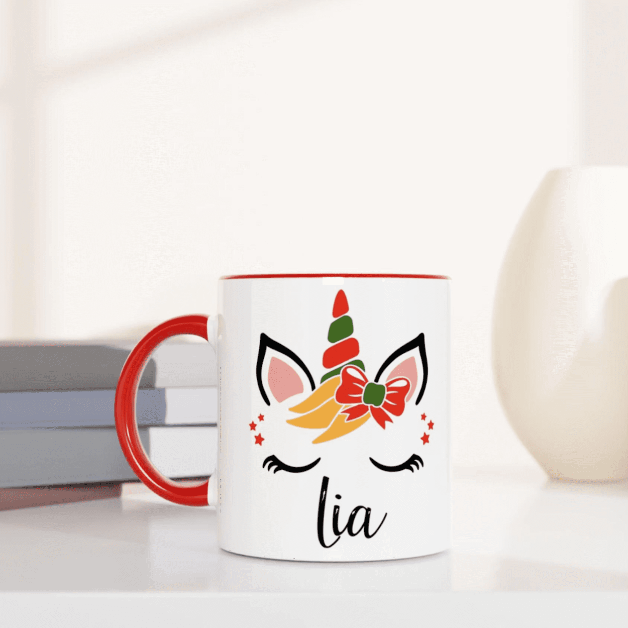 Mug licorne de Noël décoré d’un noeud rouge, anse rouge et intérieur rouge, design festif avec étoiles.