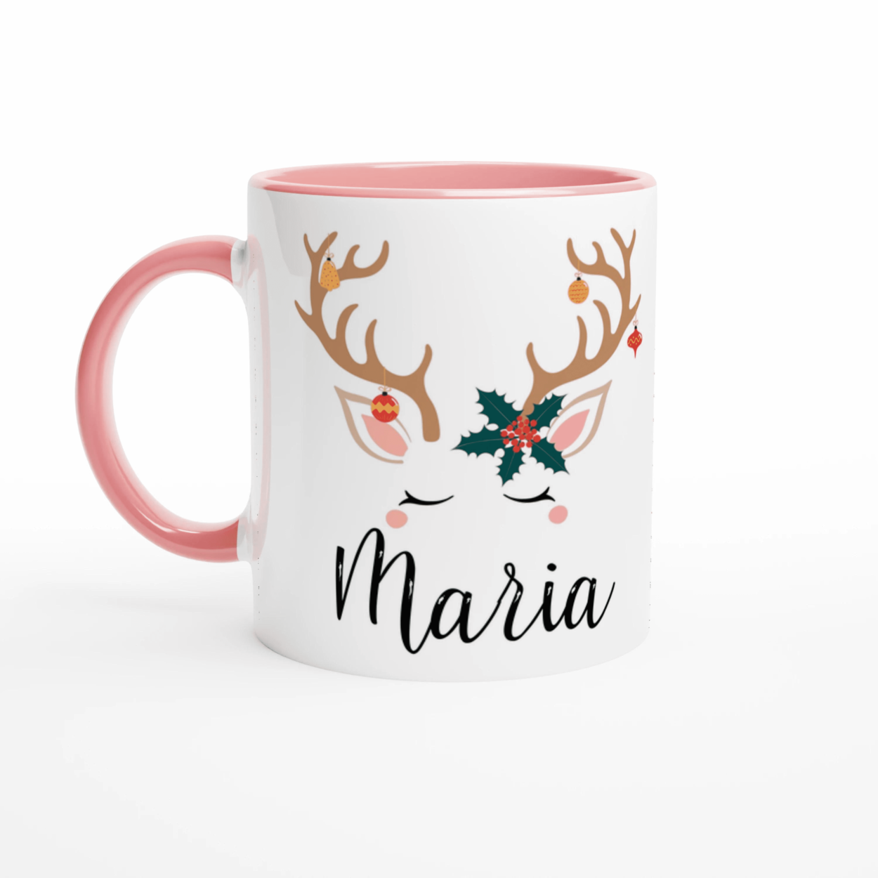 Mug de Noël décoré d’un renne aux bois ornés de décorations et feuille de houx, anse rose et intérieur rose.