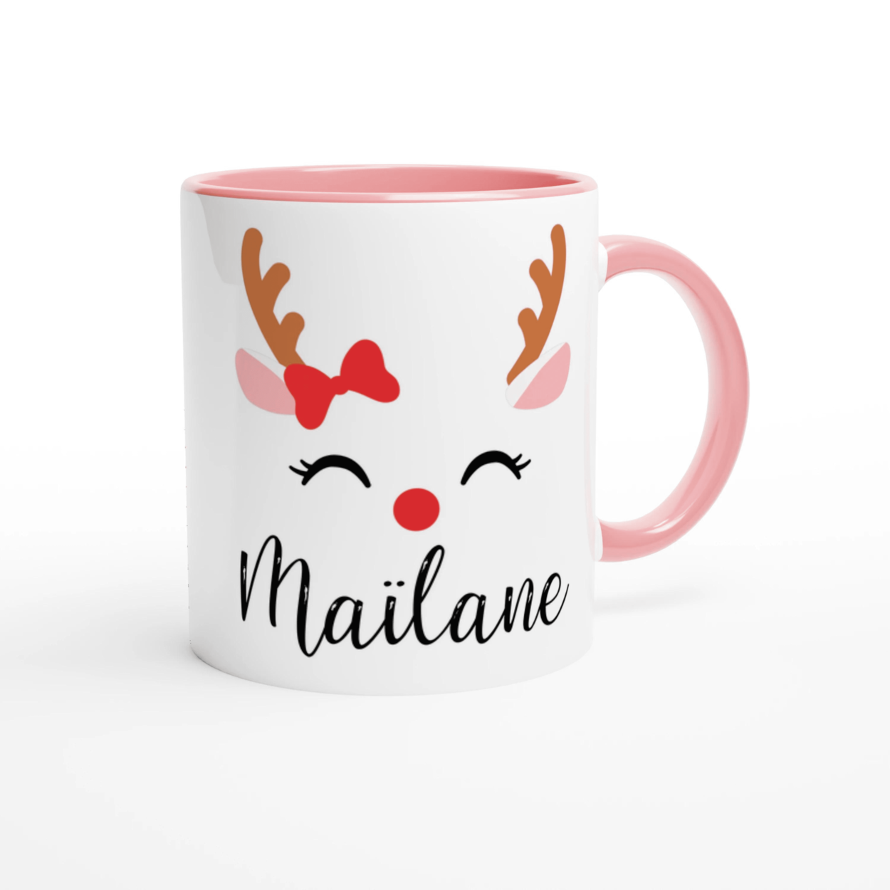 Mug de Noël décoré d’un renne festif avec nœud rouge et bois stylisés, anse rose et intérieur rose.