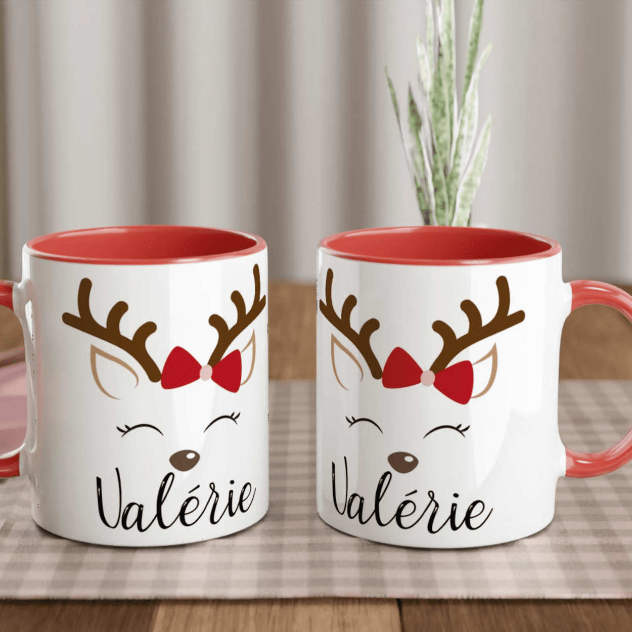 Mug de Noël blanc décoré d’un renne aux yeux fermés avec nœud rouge, anse rouge et intérieur rouge.