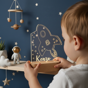 Enfant tenant une veilleuse lumineuse en forme de fusée dans une chambre décorée.